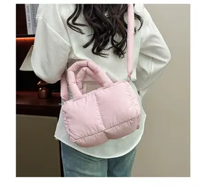 Vista posteriore di una borsa imbottita rosa trapuntata con manici e tracolla