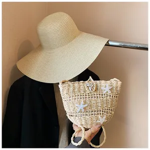Détail du sac en paille tressée avec étoiles de mer blanches et accents de coquillages