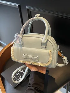 Light blue bowling bag with lace trim and bow, held against a minimalist background