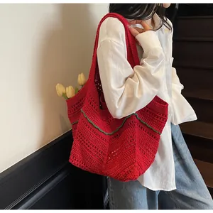 Detailed close-up of red crochet tote bag with green wavy edges and hollow knit pattern
