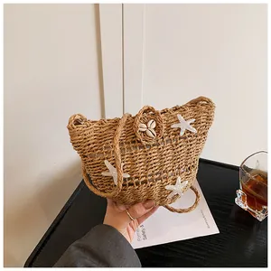 Détail d'un sac en paille avec des étoiles de mer à paillettes et un fermoir coquillage