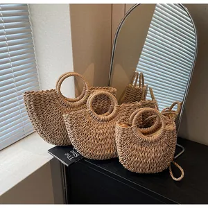 Trois sacs à main en paille tressée de tailles variées avec poignées rondes pour la plage