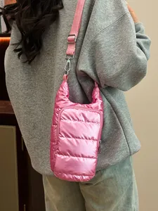 Vibrant pink quilted puffer crossbody bag with adjustable strap and shiny satin finish