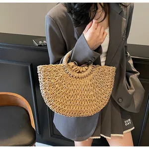 Détail du sac en paille tressée en demi-lune avec doublure intérieure à cordon serré