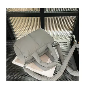 Dettaglio macro della borsa trapuntata grigia in nylon con texture morbida imbottita