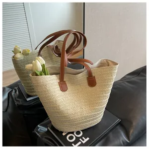 Détail du sac cabas en paille tissée main avec anses en cuir marron et texture
