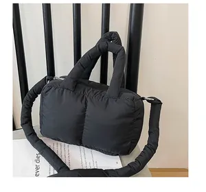 Dettaglio della borsa imbottita nera in nylon impermeabile con tracolla larga