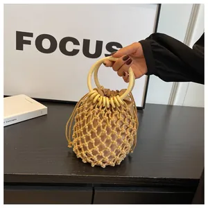 Detail der beigen Häkeltasche mit Holzringgriffen und Kordelzug-Innentasche aus Stoff