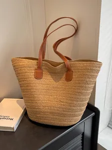 Sac cabas minimaliste en paille tissée avec anses brunes pour vacances à la mer
