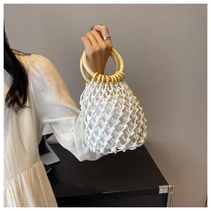 Details der böhmischen weißen hohlen Webhandtasche mit natürlichen Holzringgriffen