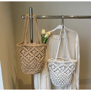Detail van handgemaakte macramé tas met geometrisch opengewerkt patroon en trekkoordvoering