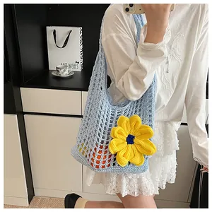 Detalle del bolso de ganchillo azul claro con flor amarilla que muestra la malla calada