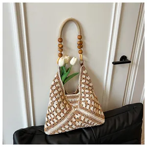 Detailed macro view of bohemian crochet tote with diamond patterns and wooden bead handles