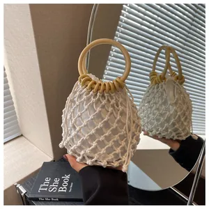 Detail einer Boho-Netztasche in Weiß mit Holzgriffen und Kordelzug-Innentasche aus Baumwolle