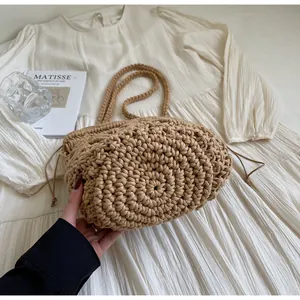 Detailopname van beige geweven emmertas met trekkoordsluiting en rijke textuur