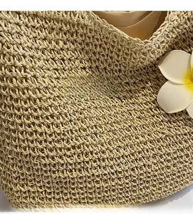 Close-up of the fine straw weave texture and smooth silk lining on a summer beach tote bag
