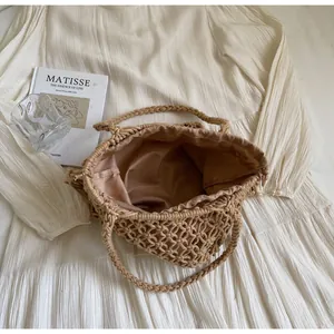 Detail van beige gehaakte tas met satijnen voering en gevlochten handvatten