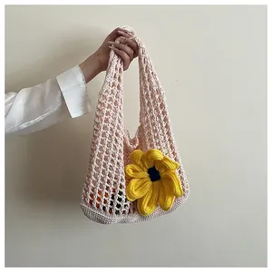 Detalle del bolso tote de ganchillo rosa con una flor amarilla grande y tejido de malla