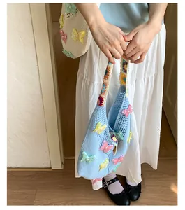 Nahaufnahme der handgefertigten Stricktasche mit 3D-Schmetterlingsapplikationen und Perlen