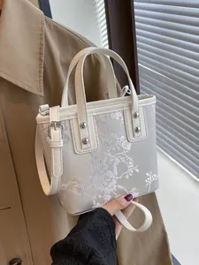 Elegant off-white embroidered bucket bag with floral patterns and silver hardware
