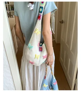Detail einer handgefertigten Stricktasche mit 3D-Schmetterlingen und bunten Trägern