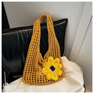 Detalle de bolsa de ganchillo amarilla hecha a mano con flor 3D y patrón de malla grande