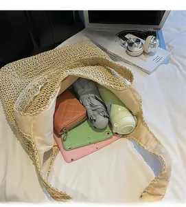 Spacious interior of a large beige straw tote bag showing umbrella and tablet storage