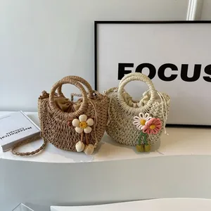 Detail of woven straw bags with knitted flower charms and drawstring lining for beach vacation