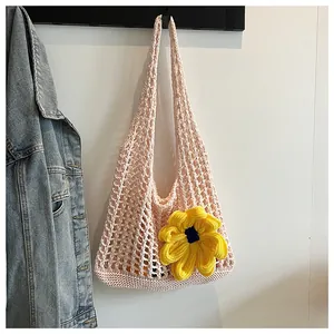 Detalle de bolso de ganchillo rosa con gran flor amarilla para vacaciones en playa