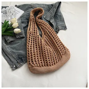 Detalle de un bolso de playa de ganchillo marrón con diseño de malla grande calada