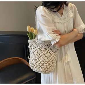 Detail van witte macramé geweven tas met bohemien patronen en handig trekkoordje