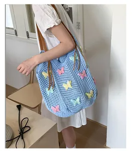 Détail du sac cabas en crochet avec broderies de papillons 3D colorés et anses marron