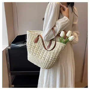 Detail of hand-woven straw tote with brown leather handles and interior tulip decoration
