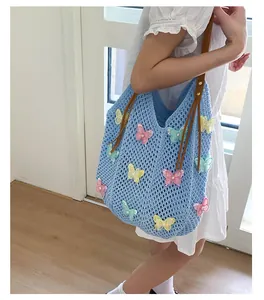 Détail du sac cabas au crochet bleu clair avec papillons 3D et lanières en cuir marron