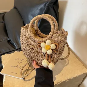 Macro detail of hand-woven semi-circle straw bag with a white floral 3D ornament