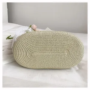Close-up of spiral woven base on beige straw beach bag with delicate lace trim