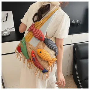 Detail of knit shoulder bag with long fringes and colorful plush fish ornaments