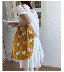 Détail du sac de plage tricoté jaune avec papillons 3D colorés et anses en cuir élégantes