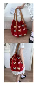 Détail du sac de plage crochet rouge avec papillons 3D et anses en cuir marron