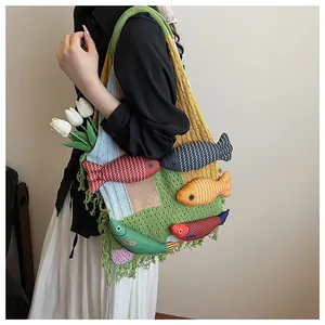 Detailed knit tote bag with colorful patchwork, 3D fish charms, and boho fringe trim