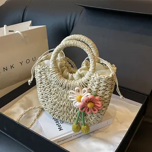 Detailed texture of handwoven straw bag featuring delicate knit flowers and drawstring liner
