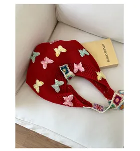 Detailansicht der roten Stricktasche mit bestickten Schmetterlings-Patches und Perlen