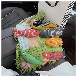 Detail of colorful knitted tote bag featuring 3D fish ornaments and green yarn fringes