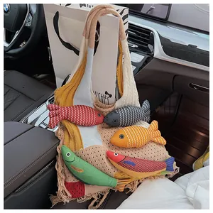 Close-up of bohemian knit tote bag with colorful 3D fish dolls and fringe detail