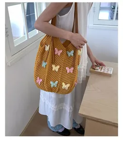 Gros plan du sac de plage crochet jaune avec broderies papillon colorées et anses brunes
