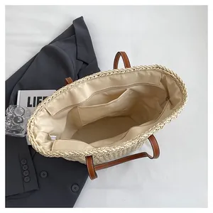 Macro view of interior fabric lining and leather handle details on woven straw tote