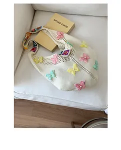 Detail der Stricktasche mit 3D-Spitzen-Schmetterlingen und buntem Blumen-Gurt