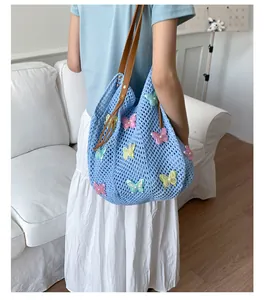 Détail du sac cabas en crochet bleu clair avec paillettes papillon et lanières brunes