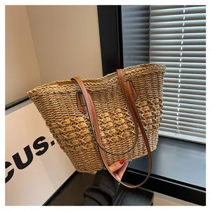 Detail of hand-woven straw tote with 3D spherical texture and brown leather straps