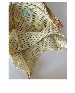 Détails d'appliqués papillon en maille et texture tissée main sur un sac de plage
